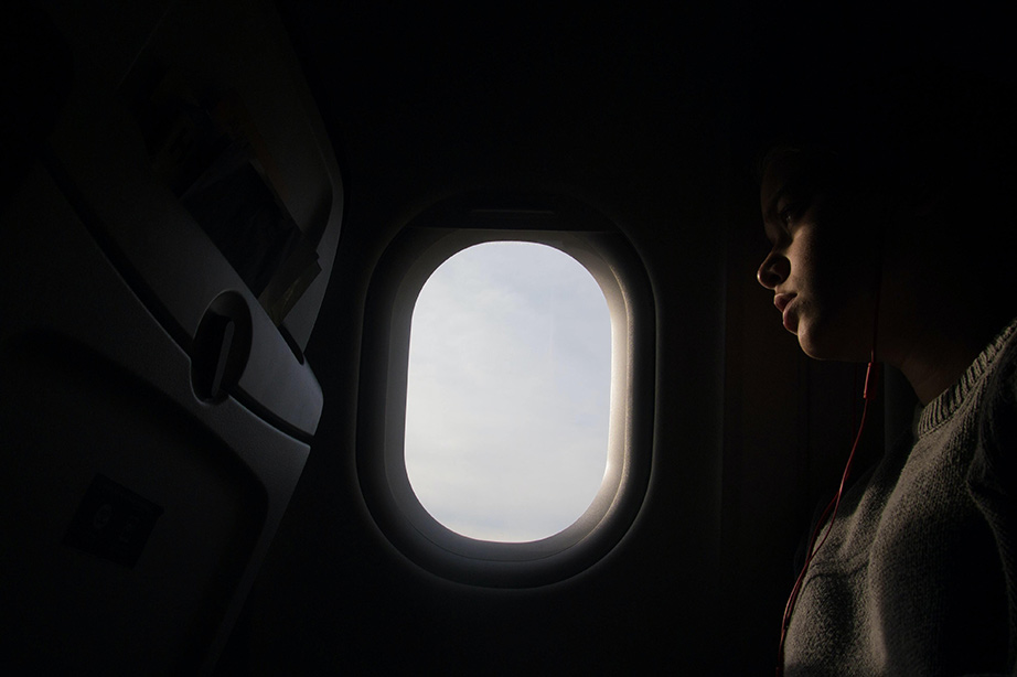 passagier in vliegtuig kijkt door raampje naar buiten